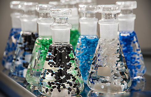 Erlenmeyerkolben mit transparenter Flüssigkeit und bunten Polymeren
