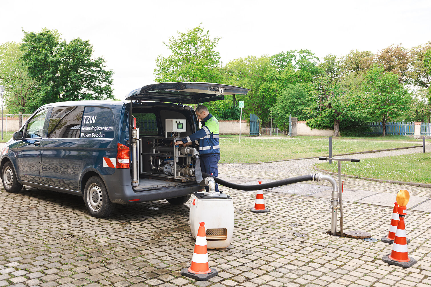 Person am Spülfahrzeig bei laufender Spülung