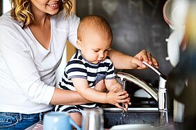 Woman and infant at water tap