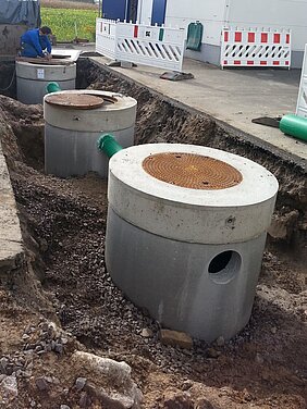 Erdgraben mit eingebauten Betonrohren für den Bau eines Großbrunnens.